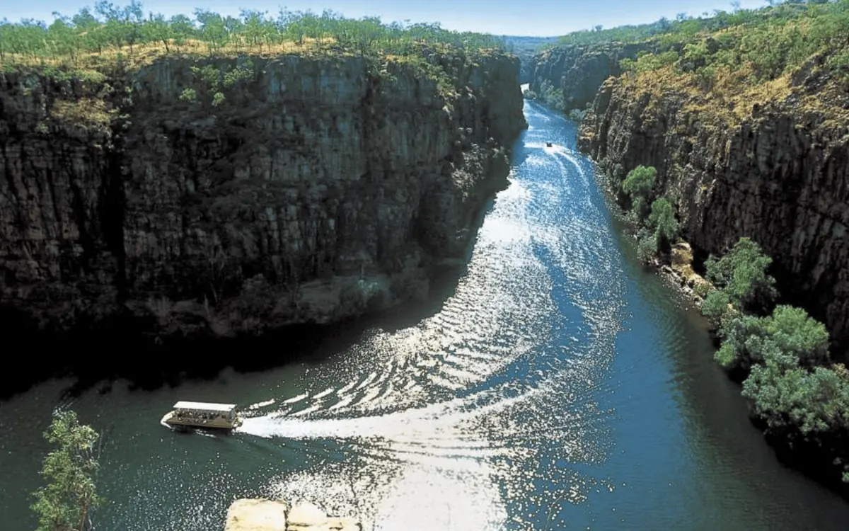 A flat-topped tour boat heading up the first gorge between sheer rock walls
