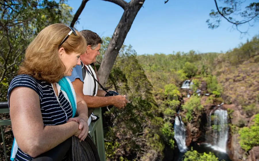Two women at a lookout rail, a waterfall and the gorge behind them