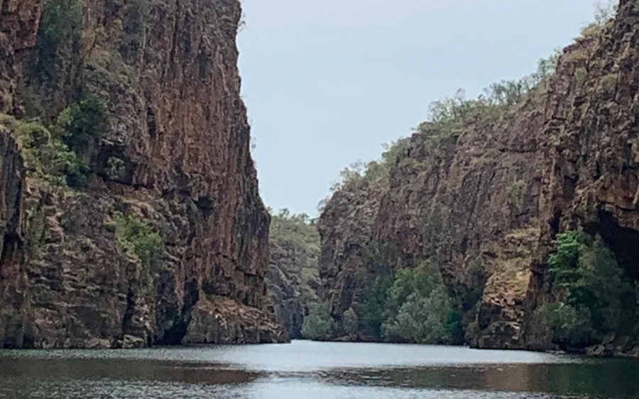 Still water between two tall dark gorge walls, seen from the level of the river